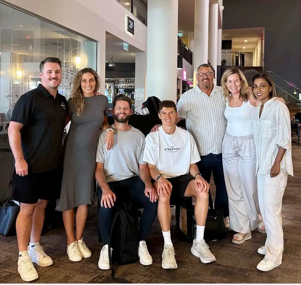 Smiling group of Happiness Co team members gathered indoors for a casual dinner meeting at a modern venue